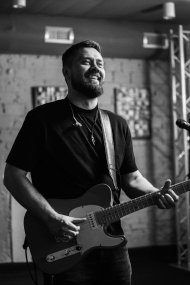 a man wRelease your video on JioSaavn without a labelith a beard playing a guitar